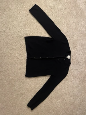 Svart kofta från H&M XS - Klassisk men skit snygg mörkblå stickad  kofta från H&M i storlek XS. Koftan har långa ärmar, rund halsringning och knappar framtill. Perfekt att slänga över en topp eller bära stängd för en clean look. Enkel och stilren design som funkar till det mesta. Den är lite nopprig men absolut inget man tänker på! Nytt pris var 300 kr men jag säljer för 125 kr💗💗