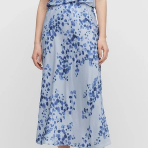 Adoore  - Supersnygg långkjol i ljusblå satin med blommigt mönster i mörkblå toner. 