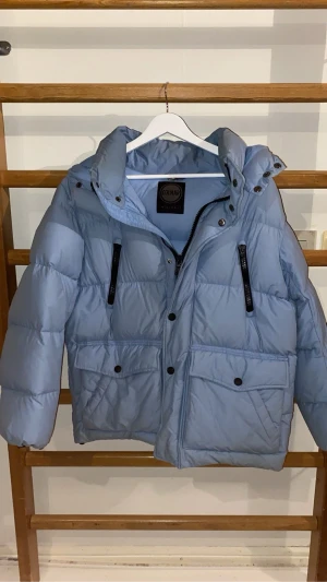 Babyblue Colmar vinterjacka - En väldigt skön och varm vinterjacka från Colmar! Färgen är babyblue och i storlek S men kan även passa XS. Jackan är använd en vinter så finns lite smuts här och där, därav priset. Men inga hål eller andra skador som inte går att fixa!