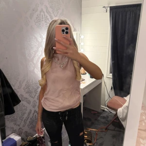 Ljusrosa linnetopp från Zara - Säljer en ljusrosa linnetopp från Zara i storlek S. Toppen har en mjuk, slät yta och är ärmlös med en lätt draperad halsringning. Materialet är glansigt och känns lyxigt, perfekt för att lyfta din outfit. Enkel och stilren design som är lätt att matcha.