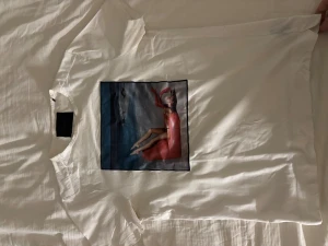 limitato T-Shirt - Vit t-shirt från Limitato med ett stort konstnärligt tryck framtill som . Klassisk passform med rund hals och korta ärmar. Perfekt för dig som gillar unika prints och kvalitets kläder