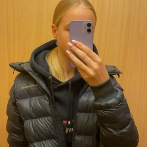 Svart pufferjacka från Peak Performance - Säljer en svart pufferjacka från Peak Performance med hög krage och dragkedja framtill. Jackan har en stilren, quiltad design och är tillverkad i glansig polyester. Perfekt för kalla dagar och har en schysst oversized look som är riktigt trendig just nu. Säljer då jag inte har någon användning utav den. Kostar ca 3000kr ny och den är inprincip ny och säljs inte längre därav priset 
