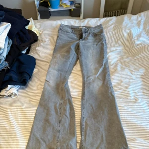 Grå bootcut jeans från Perfect Jeans - Snygga grå jeans från Perfect Jeans i storlek 38. Modellen har klassisk bootcut och fem fickor, med normal passform och midwaist. Jeansen är tillverkade i mjukt denimtyg och har dragkedja och knapp framtill.