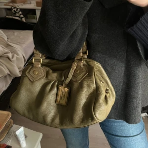 Autentisk Marc Jacobs Classic Q baby groove väska i olivgrön - Classic Q Marc Jacobs väska i fint skick. Fungerar som en everyday väska som rymmer det viktiga. Jättefin olivgrön färg i 100% riktigt läder. Kommer packas ansvarsfullt vid frakt!