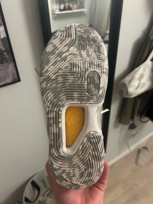 Nike KD 14 sneakers i grått och vitt - Nike KD 14 sneakers med coolt mönstrad mesh i ljusgrått och vitt, svart swoosh på sidan och transparent rem över snörningen. Skorna har rund tå, platt sula och detaljer i silver på hälen. Perfekt för dig som gillar basket eller vill ha en unik sneaker.