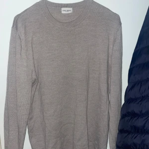 John Henric stickad  - Säljer en stilren beige stickad tröja från John Henric i merinoull. 