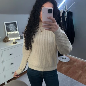 Beige stickad polotröja FB Sister XS - Säljer en beige stickad tröja från FB Sister i storlek XS. Tröjan har ribbad struktur, lite högre krage och långa ärmar. Den är i en ljus beige ton och har en klassisk, lite loose passform som är både chill och snygg. Perfekt nu under hösten och vintern💕Den är lite nopprig på framsidan men jag tror det går bort💕
