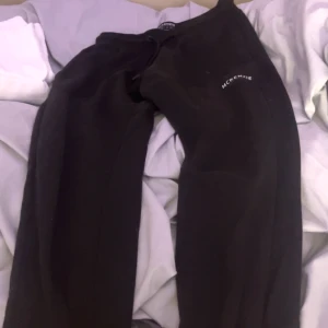 Svarta mjukisbyxor från McKenzie - Svarta mjukisbyxor från McKenzie med dragsko i midjan och logga på vänster ben. Sköna och avslappnade, perfekta för chill eller träning. Tillverkade i mjukt bomullsmaterial för extra komfort.