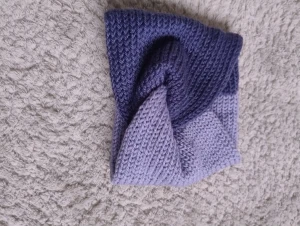 Blå stickat pannband  - Snyggt stickat pannband i två olika blå nyanser som jag gjort själv. Pannbandet har en twistad design framtill som ger en unik look. Perfekt för dig som vill sticka ut lite extra och hålla dig varm. 