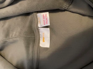 Grön velour hoodie från Gina Tricot - Mjuk och chill grön hoodie i velour från Gina Tricot. Tröjan har huva med snörning, hel dragkedja framtill och långa ärmar. Perfekt för dig som gillar comfy vibes och vill ha något snyggt och enkelt att slänga på sig.