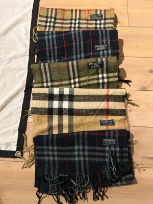 Burberry halsdukar, scarfs - Burberry scarfs/ halsdukar/350-400 beroenden färg. Skriv om ni är intresserade. Alla 5 för 1500 alltså 300 styck.