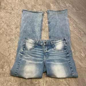 Blå bootcut jeans - Snygga blå jeans jag säljer då de bara legat i min garderob. Allt matchar med de💕Har en tunn fläck på låret som syns knappt (bild 3) samt ena benöppningen är lite sliten (bild 2) men får en coolare stil! Midjemåttet: 36 cm o innerbenslängden: 78 cm, 