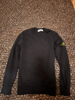 Stine Island tröja - En klassisk crewneck av Stone Island. Storlek Small. Färgen är svart och den är sparsamt andvänt. Inga defekter eller missfärgningar; nästan som ny. Nypris runt 4250 kr.