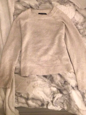 Beige/vit stickad tröja Vero Moda - Mysig beige stickad tröja från Vero Moda i storlek XS. Tröjan har rund hals, ribbade muddar vid ärmslut och nederkant samt långärmad passform. Perfekt för dig som gillar enkel och clean stil med neutrala färger. Pyttelite nopprig men inget man ser ❤️
