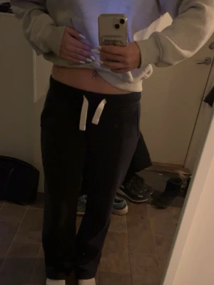 Mörkblåa Russemerch byxor  - Säljer ett par blåa russemerch mjukisbyxor med vit snörning i midjan. Byxorna har en bra passform och raka ben, perfekta för chill dagar. Materialet är mjukt och bekvämt, och de har praktiska fickor på sidorna.