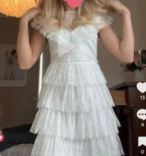 Vit studentklänning - Supersöt vit kortklänning från Bubbleroom med flera lager volanger och spetsdetaljer. Klänningen har v-ringad hals, korta ärmar i spets och ett romantiskt, fluffigt utseende. Storlek 36. Köpt för 999kr. Endast använd en gång☺️