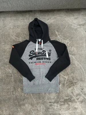 Superdry hoddie  - Superdry hoddie i grå och svart färg i storlek m