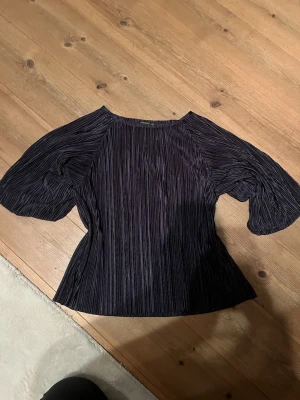 Plisserad BLÅ blus från STOCKH LM - Säljer en BLÅ plisserad blus från STOCKH LM med vida trekvartsärmar och rund halsringning. Blusen har en snygg struktur i tyget som ger en cool look och är tillverkad i ett glansigt, mjukt material. Perfekt att styla med både jeans och kostymbyxor. Den är mörkblå, se mina bilder. Nytt pris 399 kr