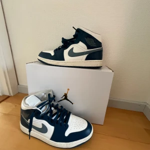 Nike Air Jordans i blått och vitt. Storlek 43 - Snygga Nike Air Jordans i en stilren kombination av blått och vitt. Skorna har den klassiska Air Jordan-loggan på sidan och snörning framtill. Perfekta för dig som vill ha en ikonisk stil.