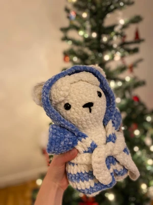 Virkad nallebjörn med morgonrock - Handgjord nallebjörn med morgonrock. Går att ta av både morgonrock och sovmask. Fylld med nallefyllning och virkad med polyester garn gjort för gosedjur. 25cm.