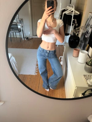 Blåa vida jeans med hög midja - Säljer ett par blåa jeans med hög midja och raka, vida ben. Klassisk femficksmodell i mjukt denimtyg. Perfekta för en avslappnad och trendig look.