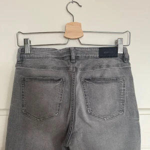 Grå bootcut jeans från Gina Tricot - Lågmidjade bootcut jeans från Gina Young. De har några få små vita fläckar (bild 4&5) och de har fläckar vid hälarna. 