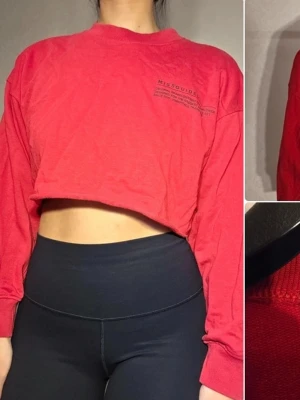 Röd cropped sweatshirt från Missguided - Cool röd cropped sweatshirt från Missguided med tryckt logga på bröstet. Tröjan har rund halsringning och långa ärmar. Perfekt för en avslappnad streetstyle-look.