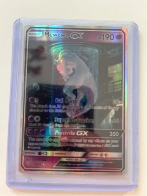 Pokémonkort Mewtwo GX holografisk - Säljer ett Pokémonkort med Mewtwo GX, holografisk yta och coolt motiv. Kortet har 190 HP och flera attacker som Full Burst, Super Absorption och Psystrike GX. Kortet ligger i ett skyddande plastfodral. Perfekt för samlare eller Pokémonfans.