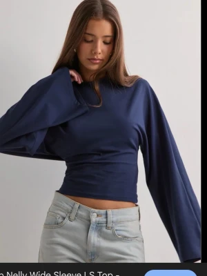 Mörkblå långärmad topp - Snygg mörkblå långärmad topp med figurnära passform och långa ärmar. Perfekt för lager-på-lager och passar till många olika stilar. Enkel och stilren design utan synliga loggor eller mönster.