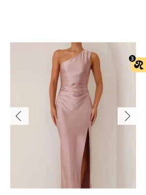 Ljusrosa långklänning i satin - Använd 2ggr, den kostar över 1000kr ny. Jag är ca 1,65 men passar något kortare& längre. Elegant ljusrosa långklänning i satin med oneshoulder-design och hög slits framtill. Klänningen har en figurnära passform och markerad midja som ger en snygg siluett. Perfekt för speciella tillfällen. (Den är skrynklig på bilden för att jag inte hann fixa, men är superlätt att göra slät)
