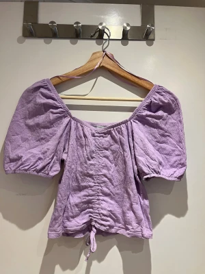 Topp med puffärm - Otroligt söt lila topp med puffärm från Cubus. Toppen har drapering därav kan man själv välja längden man vill ha. Toppen går att användas som off-shoulder modell om så önskas.