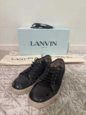 Lanvin skor - strl 39 (UK 5) - Lanvin sneakers 👟✨ Strl 39 (UK 5), men passar ca 41–42 👀💥 Komplett med allt original: låda 📦, båda dustbags 👜 och reservskosnören 👟 Skosnörena som sitter på nu är nya ✨ Onlinekvitto finns 🧾💻 Köpta från Care of Carl för 4 499 kr 💸 Perfekta för dig som vill ha snygga och stilrena sneakers 😎🔥💯 Hör av er om ni har frågor 💬