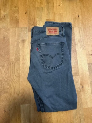 Levi's 541 grå jeans W32 L34 - Snygga grå jeans från Levi's modell 541 med klassisk femficksdesign och ikonisk läderpatch bak. Jeansen har rak passform och är tillverkade i slitstarkt denimtyg. Perfekta för en avslappnad och trendig look.