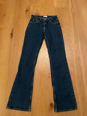 Mörkblå bootcut jeans  - Säljer ett par mörkblå bootcut jeans från Perfect Jeans från Gina Tricot. Klassisk femficksmodell med snygga kontrastsömmar och normal midja. Jeansen är i bra skick och använda ett fåtal gånger 