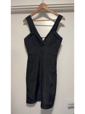 Helt NY svart klänning från VILA - Helt NY svart klänning från VILA i storlek M. Smickrande v-ringning med struktursyddda axelband. Figurnära passform och praktisk dold dragkedja i sidan. Men bäst av allt: it has pocketsssss!! Superfin och helt ny med etikett.   Hämtas i Stockholm eller skickas mot porto. 