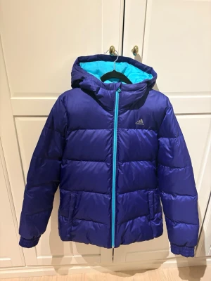 Dunjacka Adidas - Snygg dunjacka från Adidas, så fin färg på den. Mycket fint skick men små tecken på användning finns, gosig och varm.