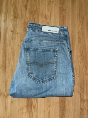 Replay jeans  - Ljusblåa jeans från Replay som har snygga fejk hål och slitningar med en rak passform. Midja 37cm, längd 101cm. JAG SKICKAR EJ FLER BILDER NÄR JAG BÄR JEANSEN! för bättre inblick i passformen rekommenderar jag att googla på modellnamnet. För storleksguide kolla måtten noggrant då jeansen alltid kan vara uppsydda heller krympta och jag ej tar emot returer :) s6,4