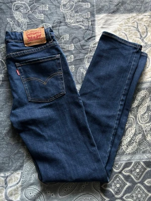 Levi's 510 Skinny jeans mörkblå - Säljer ett par Levi's 510 Skinny jeans i mörkblå denim. Klassisk femficksmodell med smal passform och normalhög midja. Jeansen har Levi's ikoniska läderpatch bak och röda logotagg vid bakfickan. Materialet är stretchigt för extra komfort.