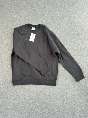 Mörkgrå sweatshirt Nike x AIK - Snygg mörkgrå sweatshirt från Nike i samarbete med AIK. Tröjan har broderad Nike-logga och AIK-text på bröstet. Klassisk rund halsringning och ribbade muddar vid ärmslut och nederkant. Perfekt för dig som gillar sportig och stilren look.