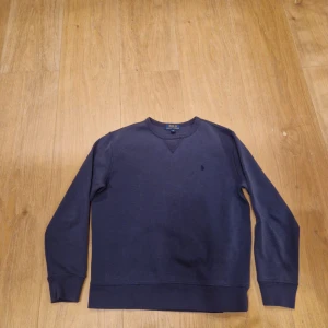 Mörkblå sweatshirt från Polo Ralph Lauren - Hej, Detta är en mörk blå rahlp lauren sweater.                     Tröjan kan känns mindre än verkliga storleken so tänk på det!  Tveka inte om ni har frågor✅