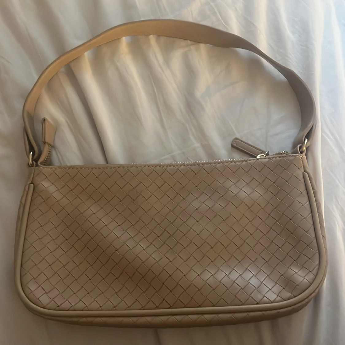 Beige axelväska i flätad skinnimitation