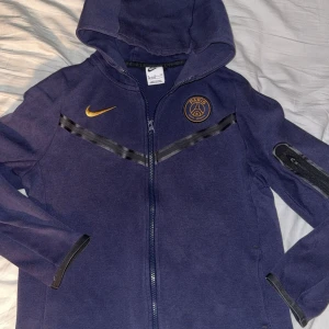 PSG x Nike tech fleece storlek XL barnstorlek  - Nike x Psg Nike tech fleece, mörkblå. Storlek XL i barnstorlek 158-170cm. Knappt använd, för liten för mig 