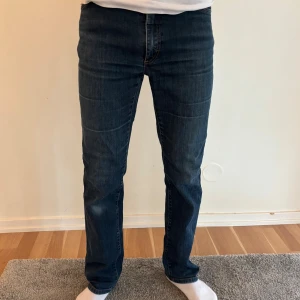 Acne Jeans Tube DC mörkblå jeans 30/34 - Mörkblå jeans från Acne Jeans, modell Tube DC. Klassisk femficksdesign med orange kontrastsömmar och läderpatch bak. Jeansen är raka i modellen och har en snygg tvätt med lätt slitning. Materialet är 98% bomull och 2% elastan för lite stretch. Modellen är 180 och väger 65kg! (Plagget skickas inom 24h efter köp!) Hör av dig vid frågor🙂
