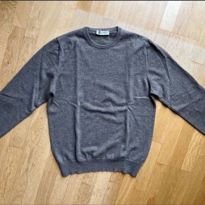 Brun kashmirtröja från Piacenza - Mjuk och lyxig grå tröja från Piacenza i 100% kashmir. Klassisk rund halsringning, ribbade muddar och lång ärm. Perfekt för dig som vill ha en stilren och tidlös look med premiumkänsla. Nypris 4800, helt ny utan prislapp. 