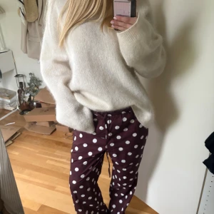 Bruna prickiga byxor med snörning - Säljer ett par bruna byxor med vita prickar och snörning i midjan. Byxorna har en avslappnad passform och raka ben.