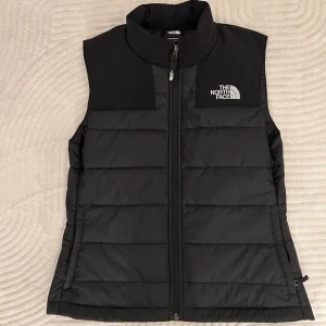 Svart dunväst från The North Face - Svart väst från The North Face. Mycket bra skick då den aldrig kommit till användning. Perfekt nu till hösten! 💕