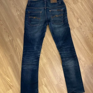 Mörkblåa Nudie Jeans - Mörkblåa Nudie Jeans i storlek 30W/32L i modell Thinn Finn! De har en femfickig design med en snygg fade. (Modell 176cm, 70kg)