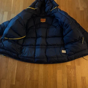 Blå Fjällrävenjacka - Säljer denna fjällrävenjacka då den sitter lite väl stort på mig enligt mitt tycke. Den är strl small men skulle säga att en person som bär Medium till vardags borde ha den. Mycket fint skick förövrigt.