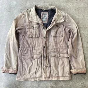 Beige fieldjacket från Wild & Rough - Fet fieldjacket från Wild & Rough med fodring för dem kallare dagarna. Vid minsta lilla fundering är det bara att fråga.