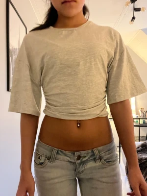 Grå soft ruched tee från gina tricot - Säljer då den inte är i min stil. Aldrig använd. Hör av er vid frågor. För referens är jag 164 cm lång.